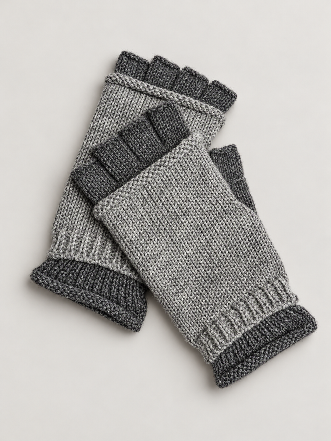 A pair of fingerless knit gloves in heather gray with dark gray ribbed cuffs and finger sections, displayed on a light gray background.